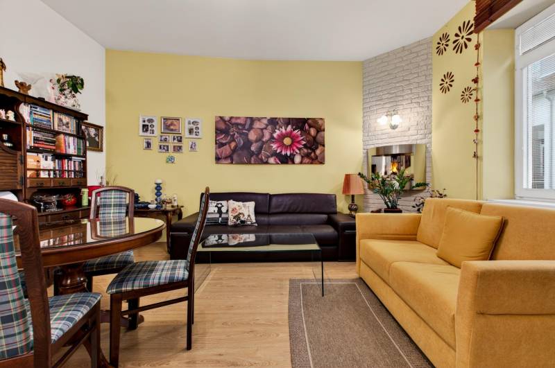 Wohnzimmer in einer 3-Zimmer-Wohnung mit Holzboden und bequemen Sitzgelegenheiten.