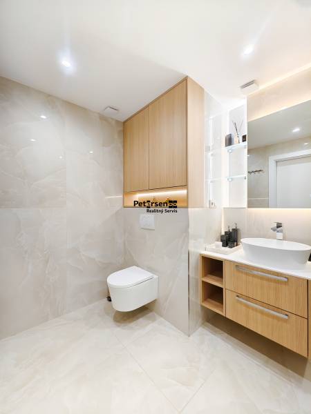 Badezimmer mit Holzboden-Dekor in einer 2-Zimmer-Wohnung, helle Fliesen und hängendes WC.