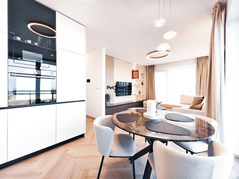 2-Zimmer-Wohnung mit Esstisch, Sofa und Boden in Holzoptik.