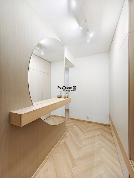 Eingangsbereich mit Holzboden und großem Spiegel in einer 2-Zimmer-Wohnung.