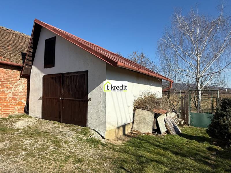 Eine Hütte in Zlaté Moravce mit Holztüren und einem schrägen Dach im Hof.