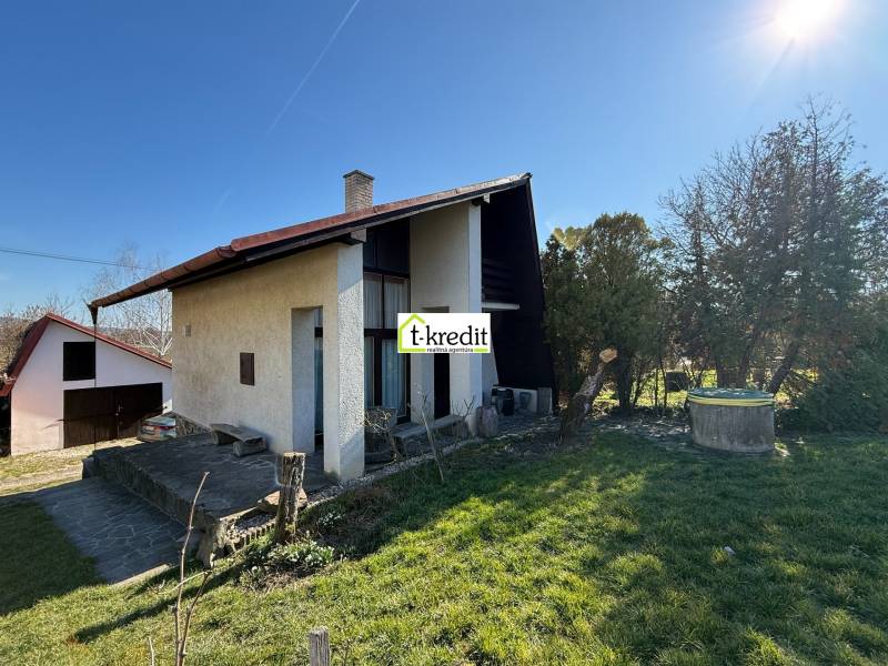Ein Ferienhaus in Zlaté Moravce, umgeben von einem Garten und Rasen unter klarem Himmel.
