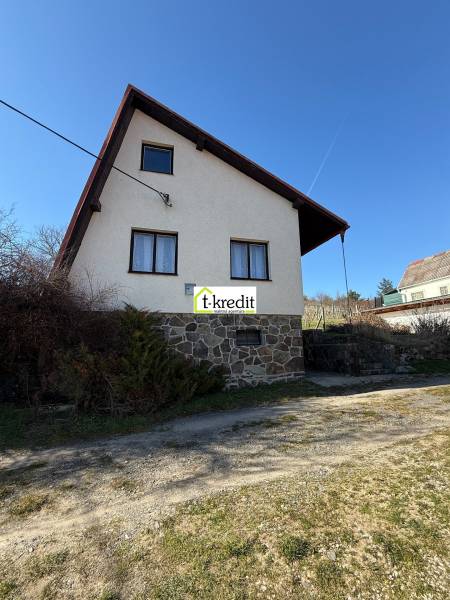 Eine Hütte in Zlaté Moravce mit einem Steinfundament und einem schrägen Dach unter blauem Himmel.