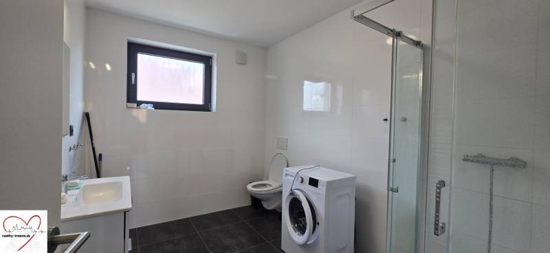 Badezimmer mit Dusche, Waschbecken und Waschmaschine in einer 3-Zimmer-Wohnung.