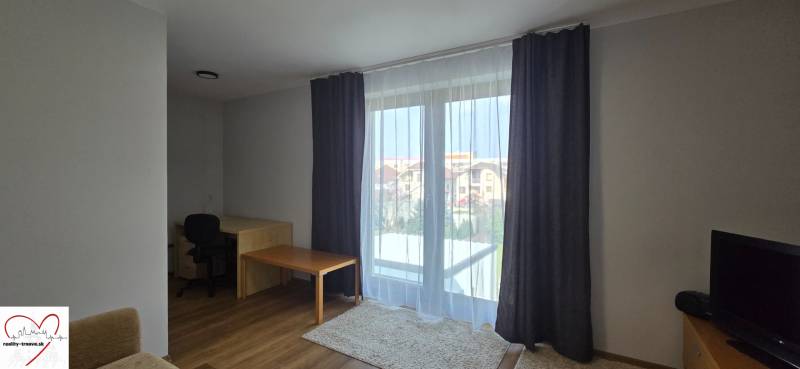 Wohnzimmer mit Tisch und Holzboden in einer 3-Zimmer-Wohnung.