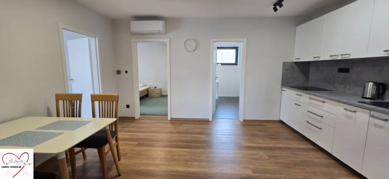 Küche in einer 3-Zimmer-Wohnung mit Holzboden und Esstisch.