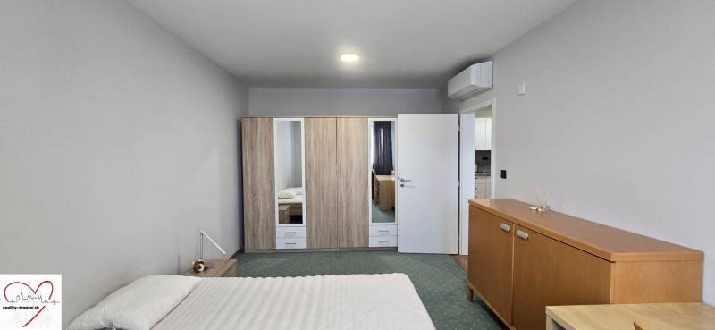 Ein Zimmer in einer 3-Zimmer-Wohnung mit Bett, Schrank, Klimaanlage und Holzmöbeldekor.