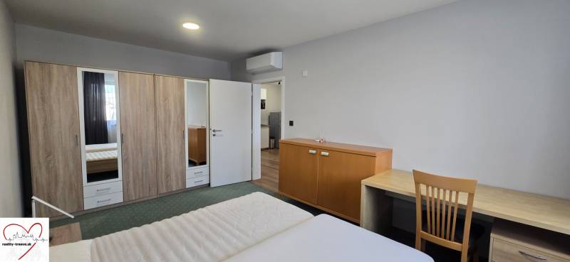 Schlafzimmer in einer 3-Zimmer-Wohnung mit Doppelbett, Schrank und Tisch.