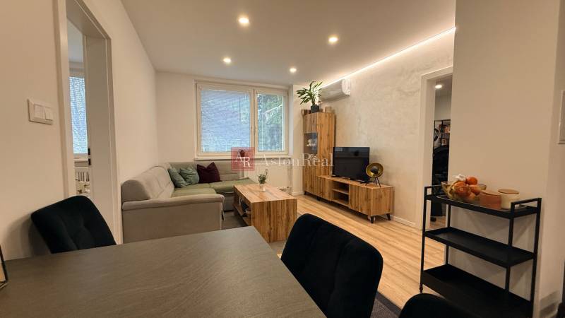 Wohnzimmer mit Sofa, Fernseher und Dekoration auf dem Boden in einer 4-Zimmer-Wohnung.