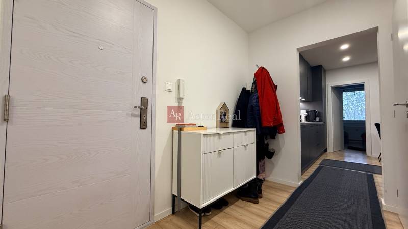 Eingangsbereich in einer 4-Zimmer-Wohnung mit weißen Türen und einem Boden in Holzoptik.