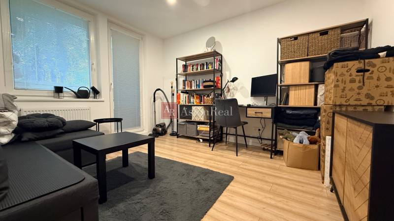 Wohnzimmer in einer 4-Zimmer-Wohnung mit Holzboden und Arbeitsecke.