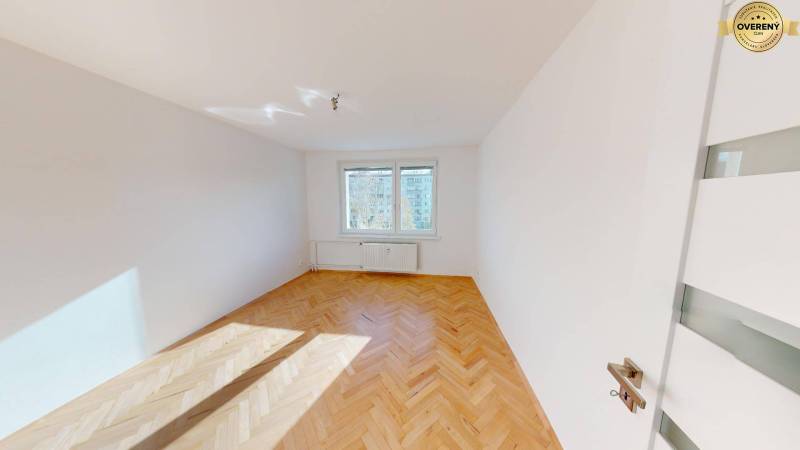 Helles Zimmer in einer 2-Zimmer-Wohnung mit Holzboden und großen Fenstern.