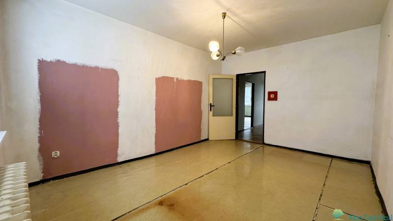 Ein Zimmer mit einzigartigen Wänden und einem Boden in Holzdekor in einer 3-Zimmer-Wohnung.