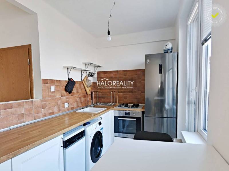 Küche in einer 3-Zimmer-Wohnung mit Holzboden und Geräten.