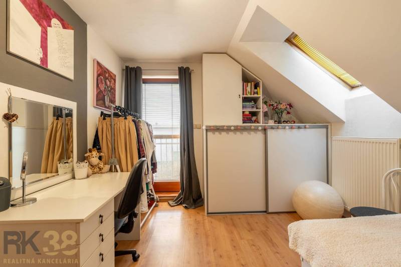 Innenraum eines Einfamilienhauses mit Holzboden, Schreibtisch und Stauraum.