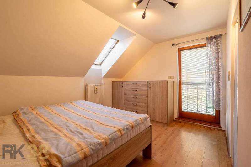 Schlafzimmer mit Holzboden und Dachfenster in einem Einfamilienhaus.