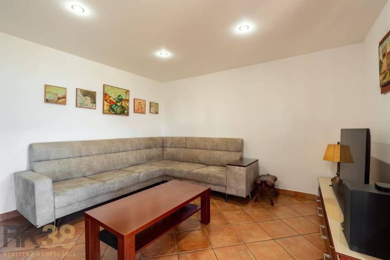 Wohnzimmer in einem Einfamilienhaus mit Ecksofa und Keramikboden.