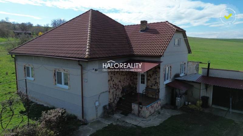 Ein Einfamilienhaus in Rimavské Janovce mit rotem Dach und ländlicher Umgebung.