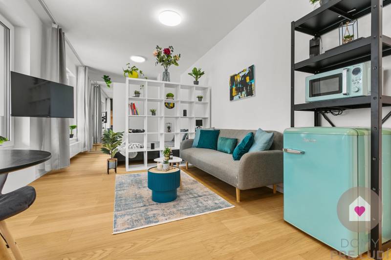 Wohnbereich in einer Einzimmerwohnung mit Holzboden und Dekorationen.