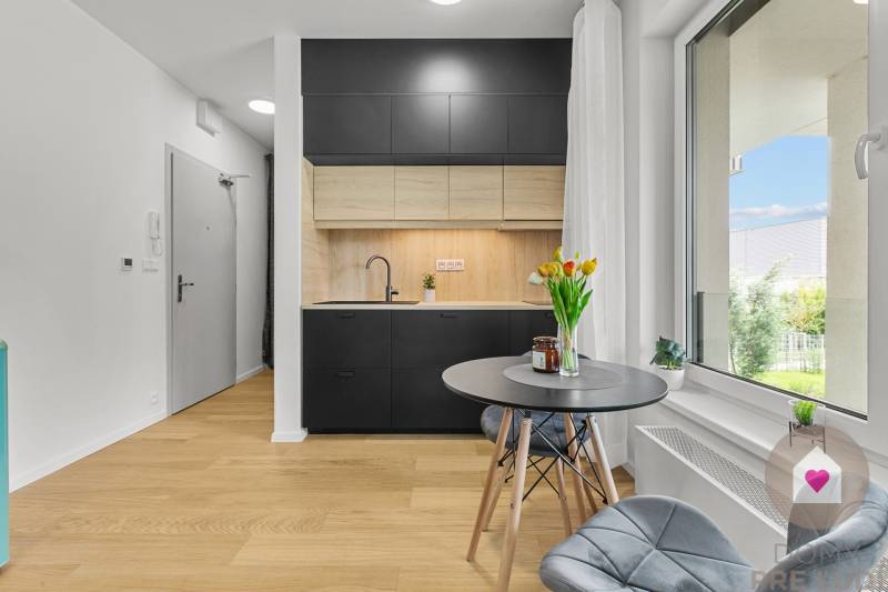 Küche mit grauen Schränken und Holzboden in einer Einzimmerwohnung.