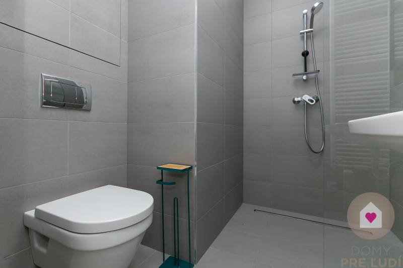 Badezimmer mit Toilette und Duschkabine in einer Einzimmerwohnung.