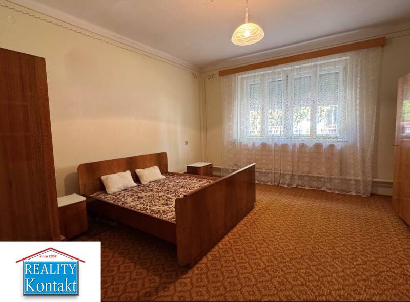 Bett mit Sessel und Nachttischen im heimischen Schlafzimmer mit Teppich.