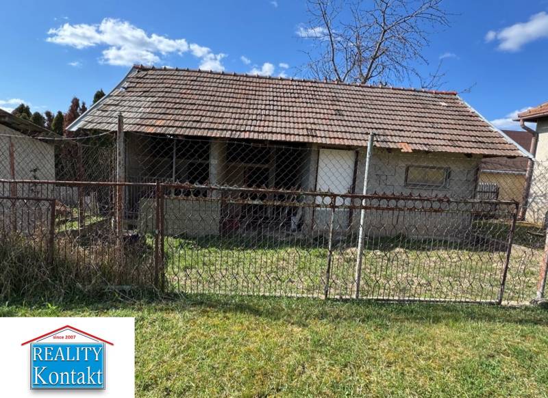 Ein Einfamilienhaus in der Hauptstraße in Radava mit einem einfachen Zaun und Rasen.