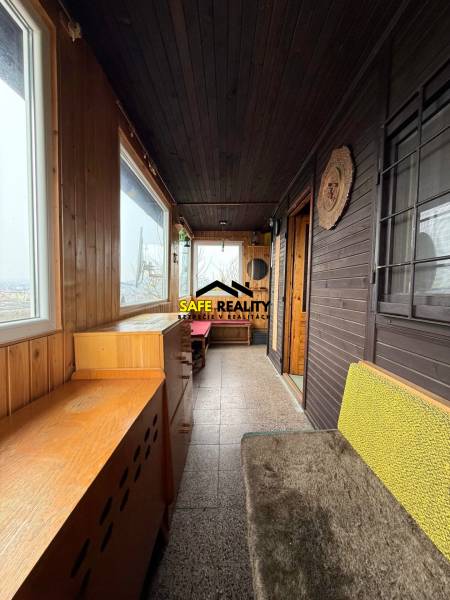 Eine Hütte mit Holzelementen, gemütlichen Möbeln und großen Fenstern mit Blick auf die Natur.