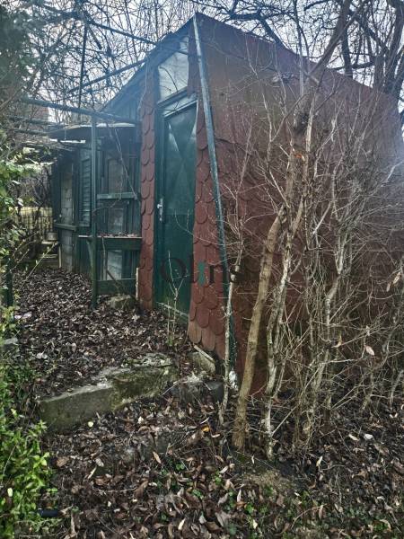 Eine Hütte in den Gärten von Nitra, umgeben von winterlicher Natur mit kahlen Ästen.