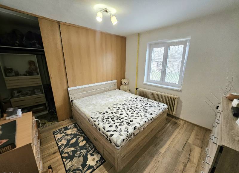 Schlafzimmer mit Bett und Holzboden in einem Einfamilienhaus.