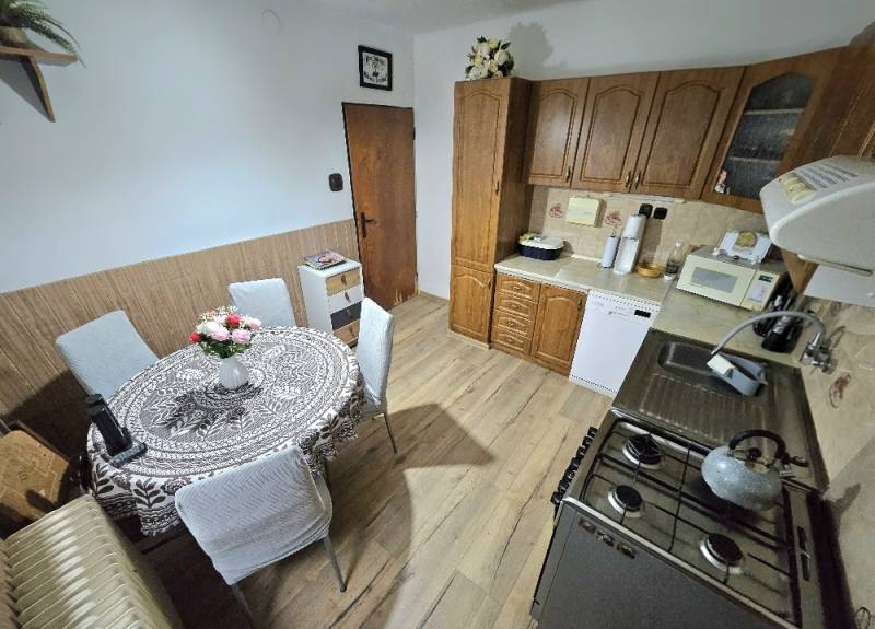 Küche in einem Einfamilienhaus mit Holzelementen und Esstisch.