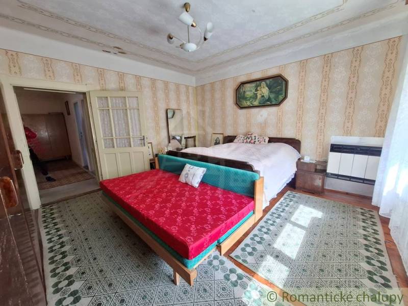 Schlafzimmer im Einfamilienhaus mit Doppelbett, Sofa und gemusterten Teppichen.