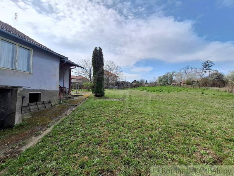 Ein Einfamilienhaus in Ľuba mit einem geräumigen Hof und grünem Rasen unter blauem Himmel.