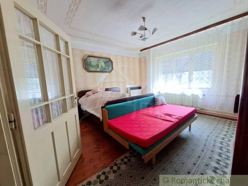 Schlafzimmer mit dekorativer Decke, Doppelbett und Teppichboden in einem Einfamilienhaus.