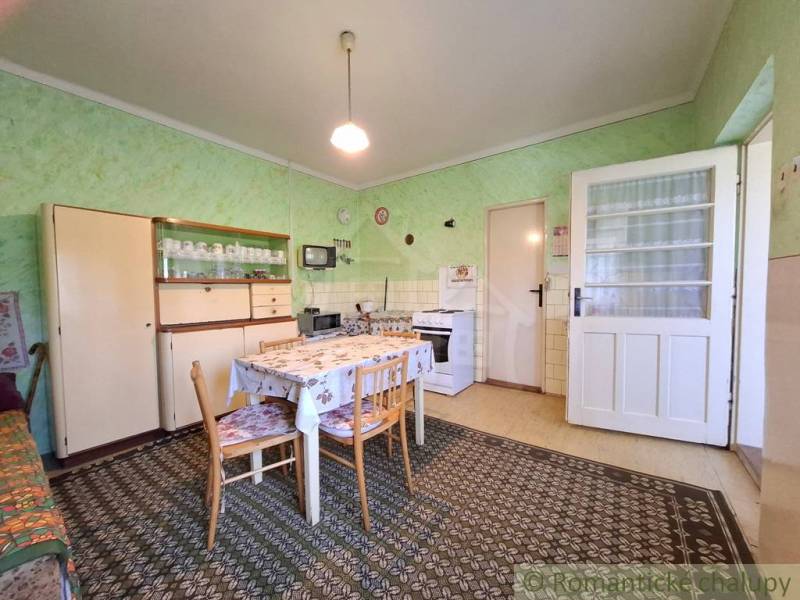 Küche in einem Einfamilienhaus mit Esstisch, Sessel und traditionellem Möbel.