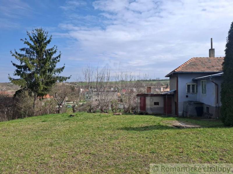Ein Einfamilienhaus in Ľuba, ein Garten mit Rasen, Bäumen und Blick auf die umliegende Landschaft.