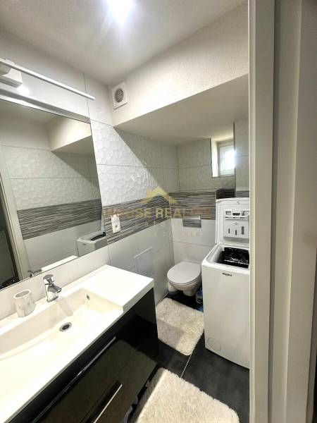Badezimmer in einer 2-Zimmer-Wohnung mit Waschbecken, Waschmaschine und WC.