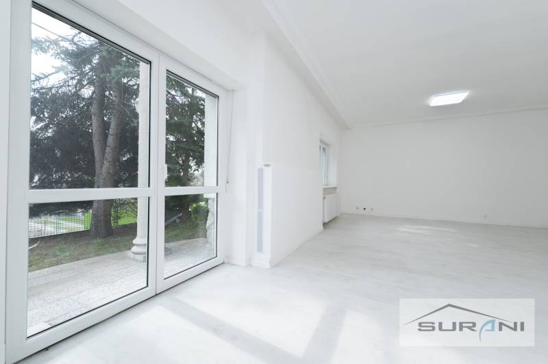 Helles Zimmer mit großen Fenstern und Holzboden in einer 4-Zimmer-Wohnung.