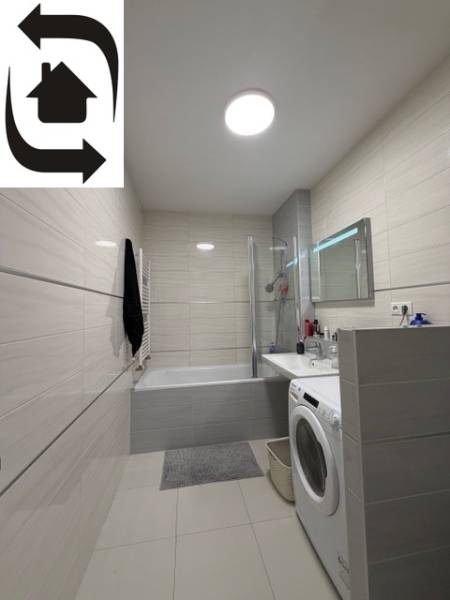 Badezimmer in einer 2-Zimmer-Wohnung mit Dusche, Badewanne und Waschmaschine.