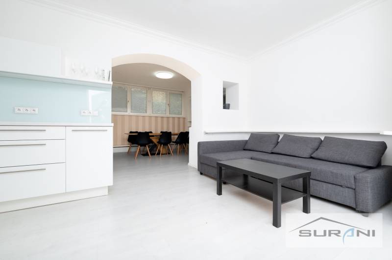 Wohnzimmer einer 4-Zimmer-Wohnung mit Küchenzeile und Sitzgarnitur.