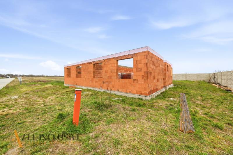 Ein unvollendetes Einfamilienhaus in Veľké Dvorníky mit nackten Ziegelwänden und leeren Fenstern.