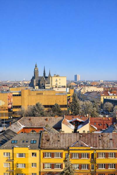 Blick auf das historische Zentrum von Košice, Türme und Gebäude, mit blauem Himmel im Hintergrund.