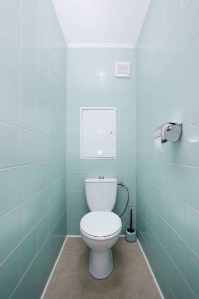 Toilette in einer 3-Zimmer-Wohnung mit hellblauen Fliesen und einem hellen Boden.