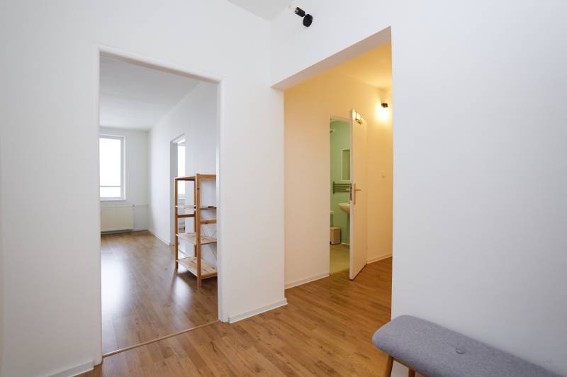 Innenraum einer 3-Zimmer-Wohnung mit Holzboden, umfasst Flur und Badezimmer.