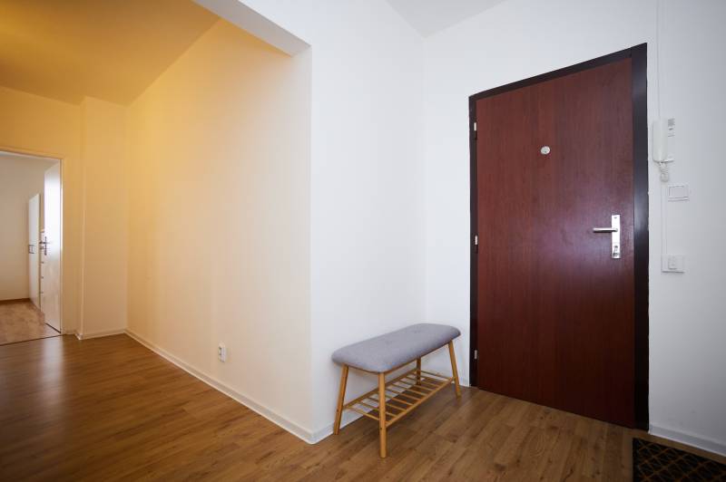 Eingangsbereich mit Holzboden und Bank in einer 3-Zimmer-Wohnung.