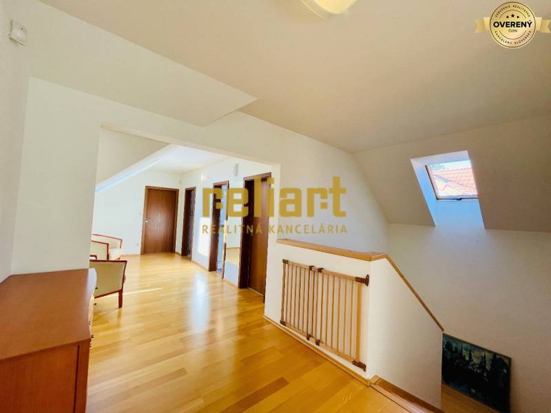 Ein Flur mit Holzboden, Dachfenster und Türen in einem Einfamilienhaus.