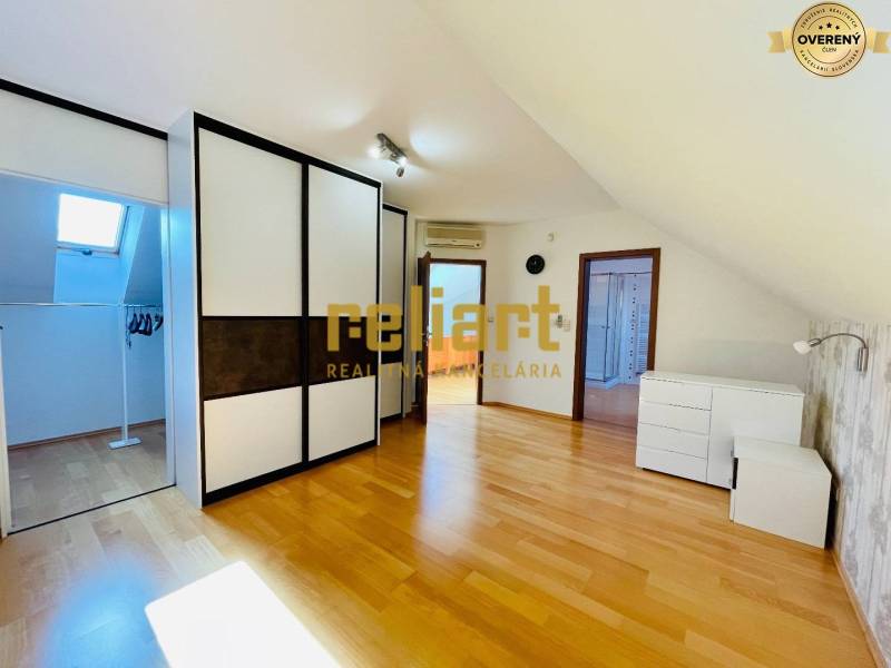 Dachzimmer mit Holzboden und Einbauschrank in einem Einfamilienhaus.
