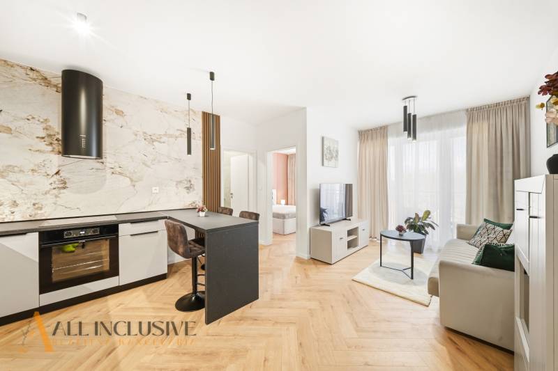 Wohnzimmer und Küche in einer 4-Zimmer-Wohnung mit Holzboden und heller Dekoration.