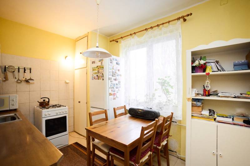 Küche in einer 3-Zimmer-Wohnung mit Tisch, Stühlen und Küchenzeile.