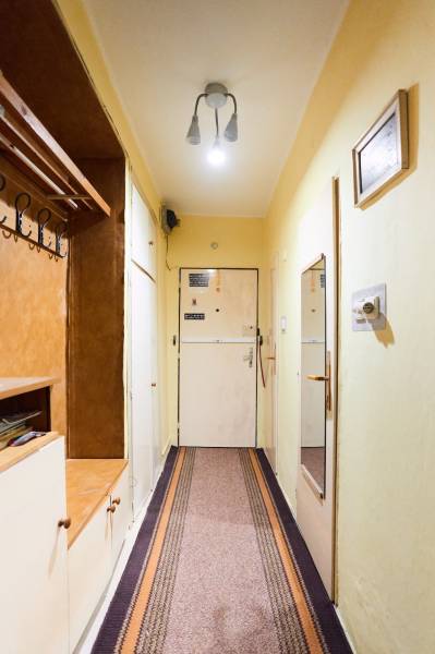 Flur in einer 3-Zimmer-Wohnung mit Garderobe, Spiegel und einfacher Beleuchtung.
